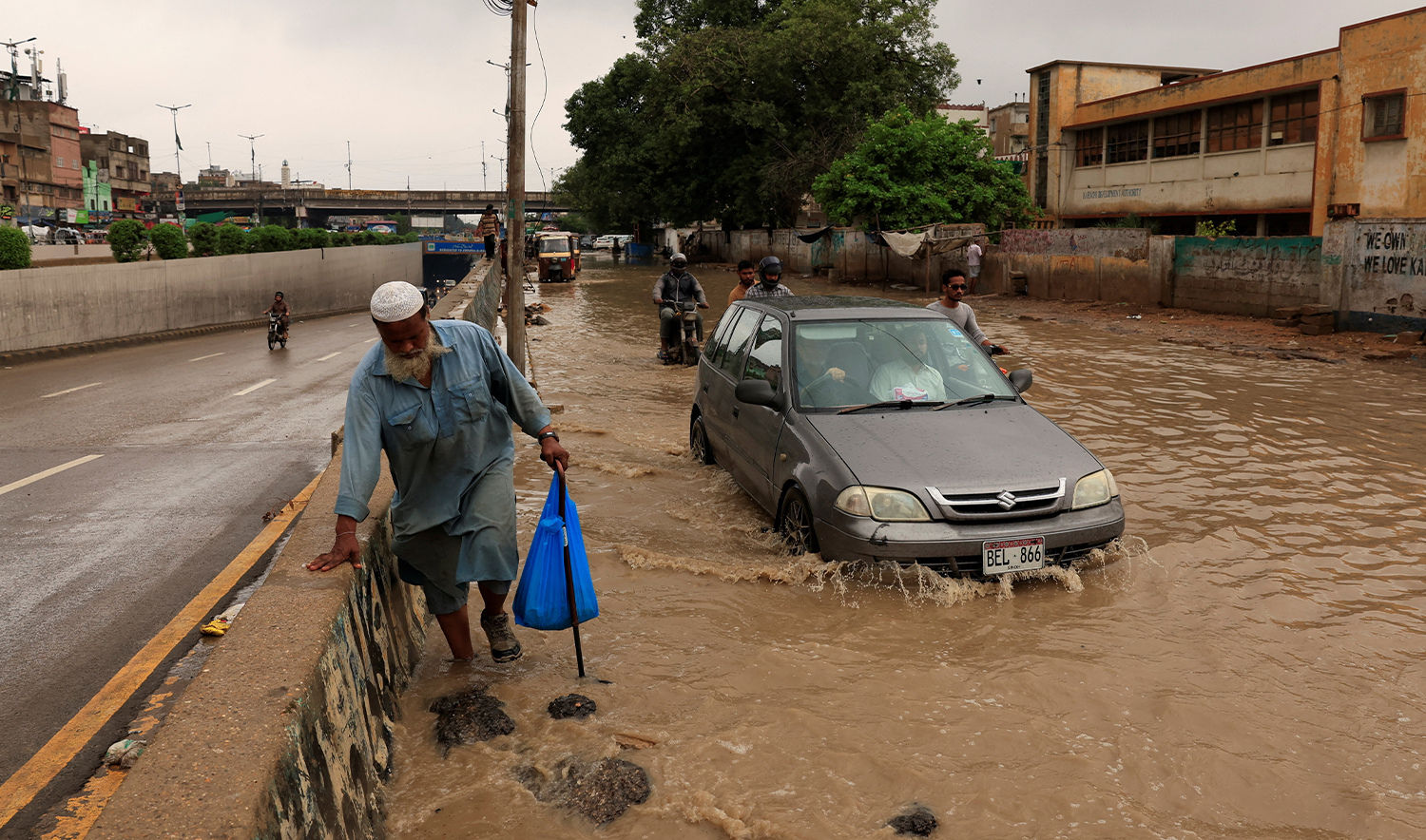 A resident walks with stick through a flooded road after a rain, following a recent monsoon season, in Karachi, Pakistan, on September 10, 2025. (REUTERS)