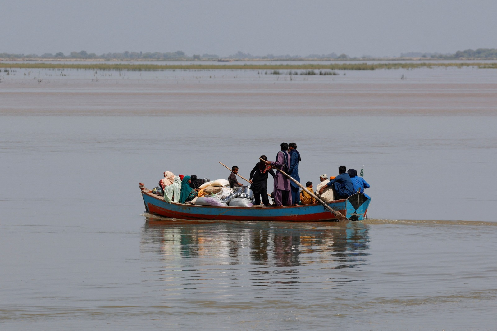 People with their supplies travel in a boat as they head to their village along the Indus River, as floodwater passes through, following monsoon rains and rising levels of the Indus River in Sukkur, Sindh province, Pakistan, September 14, 2025. (REUTERS)