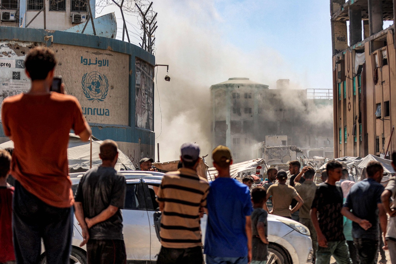 People watch as smoke dissipates following an explosion in one of the buildings of the Islamic University of Gaza in Gaza City on September 14, 2025. (AFP)