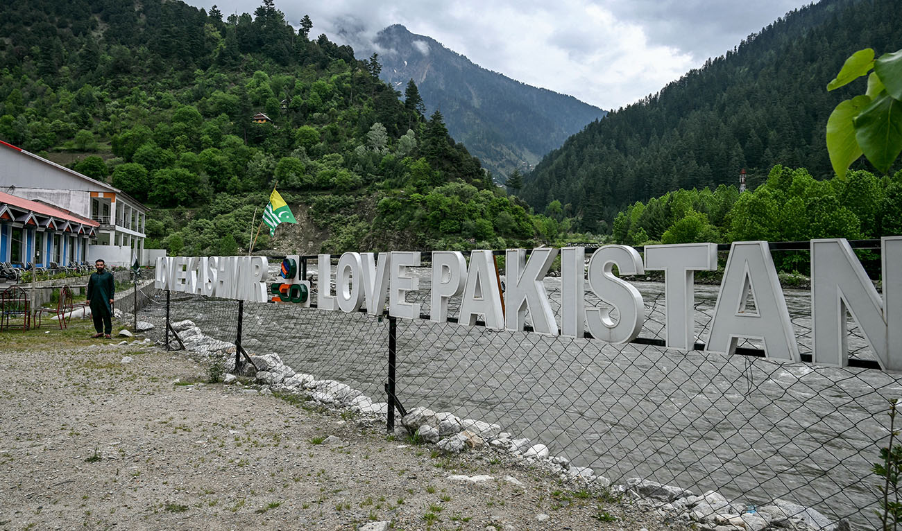 A guest house staff stands in an empty tourist place in Keran village on the Line of Control (LoC) in Neelum Valley, a district of Pakistan-administered Kashmir, on May 3, 2025. (AFP)