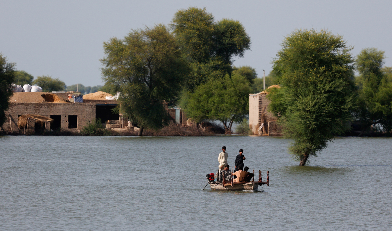 Residents travel in boat, with the partially submerged homes in the background, following monsoon rains and rising water levels of Indus River on the outskirts of Dadu, Sindh province, Pakistan on September 15, 2025. (REUTERS)