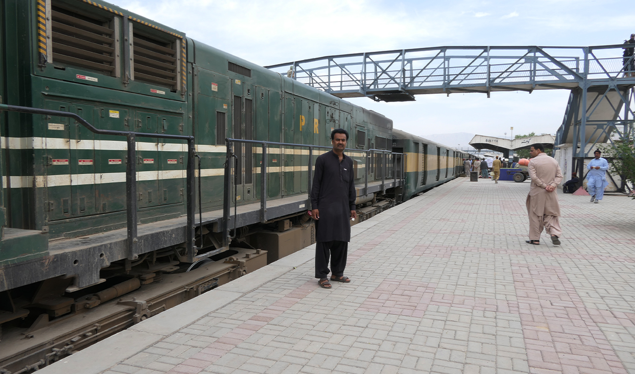 Assad Ali (left), a Pakistan Railways employee and survivor of the Jaffar Express hijacking, watches a train pass by at Quetta Railway Station in Quetta, Pakistan, on April 8, 2025. (AN/File)