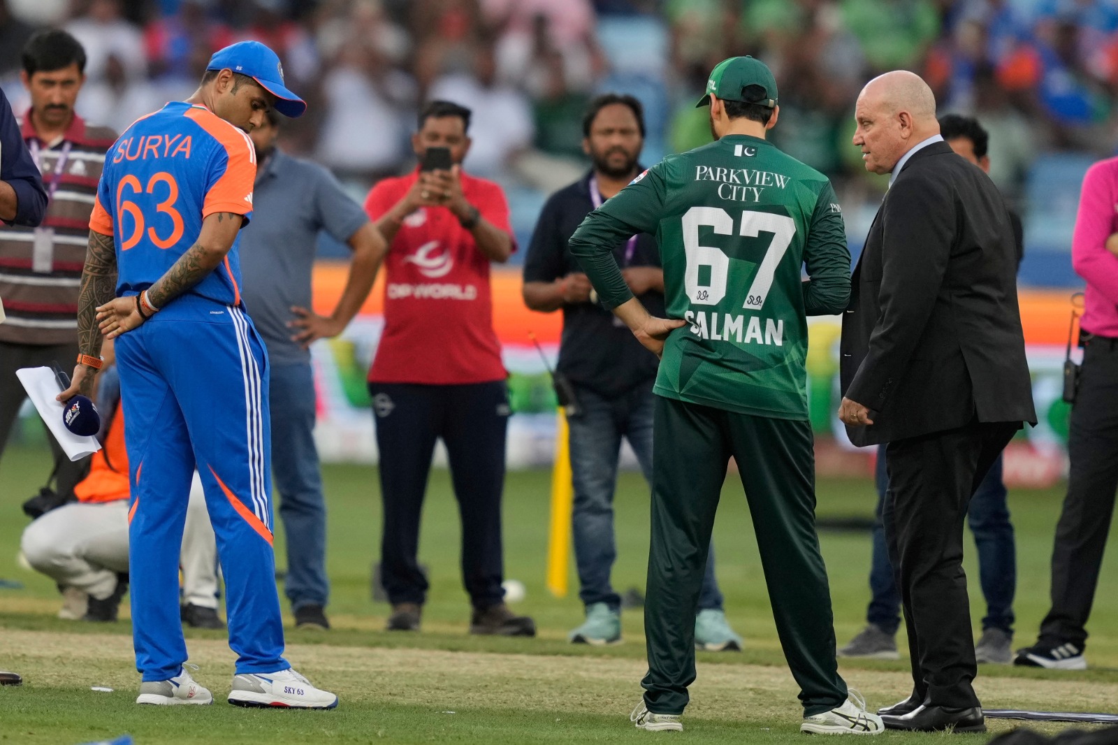 India’s captain Suryakumar Yadav, left, looks on as Pakistan’s captain Salman Agha, second from right, speaks with match referee Andy Pycroft at the toss ahead of the Asia Cup cricket match between India and Pakistan at Dubai International Cricket Stadium in Dubai, United Arab Emirates, Sunday, Sept. 21, 2025. (AP)
