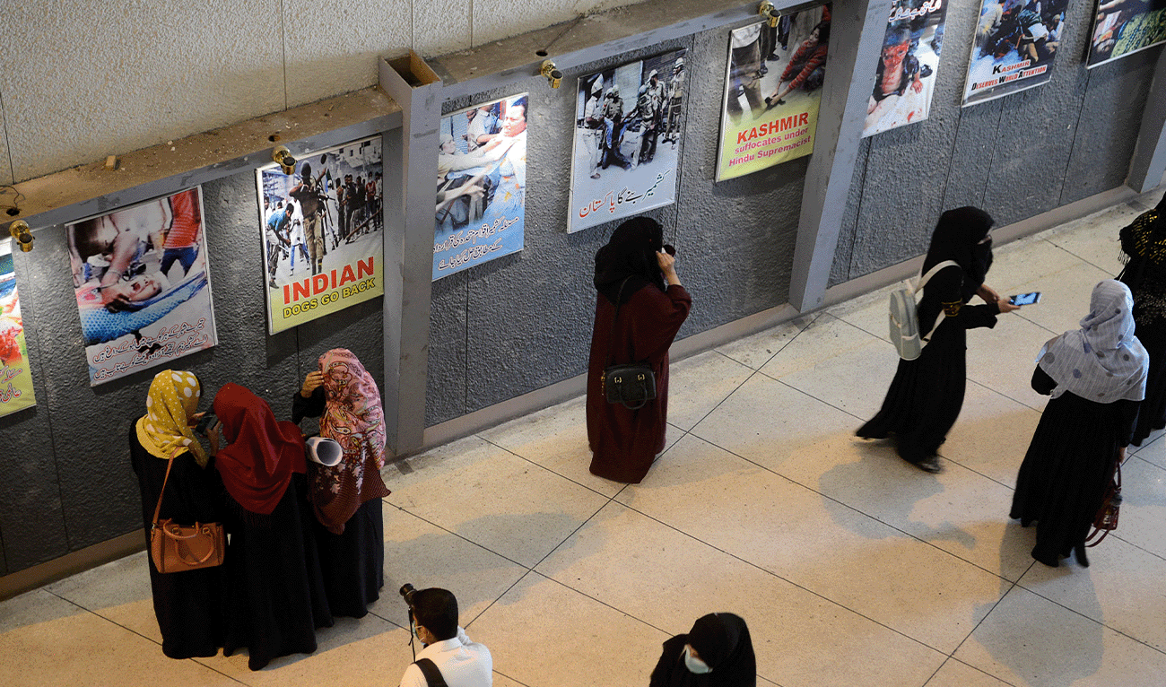 People look at wall posters on display to mark 'Black Day' commemorating the arrival of the Indian Army in Jammu and Kashmir in 1947, during an exhibition in Peshawar October 27, 2021. (AFP/File)
