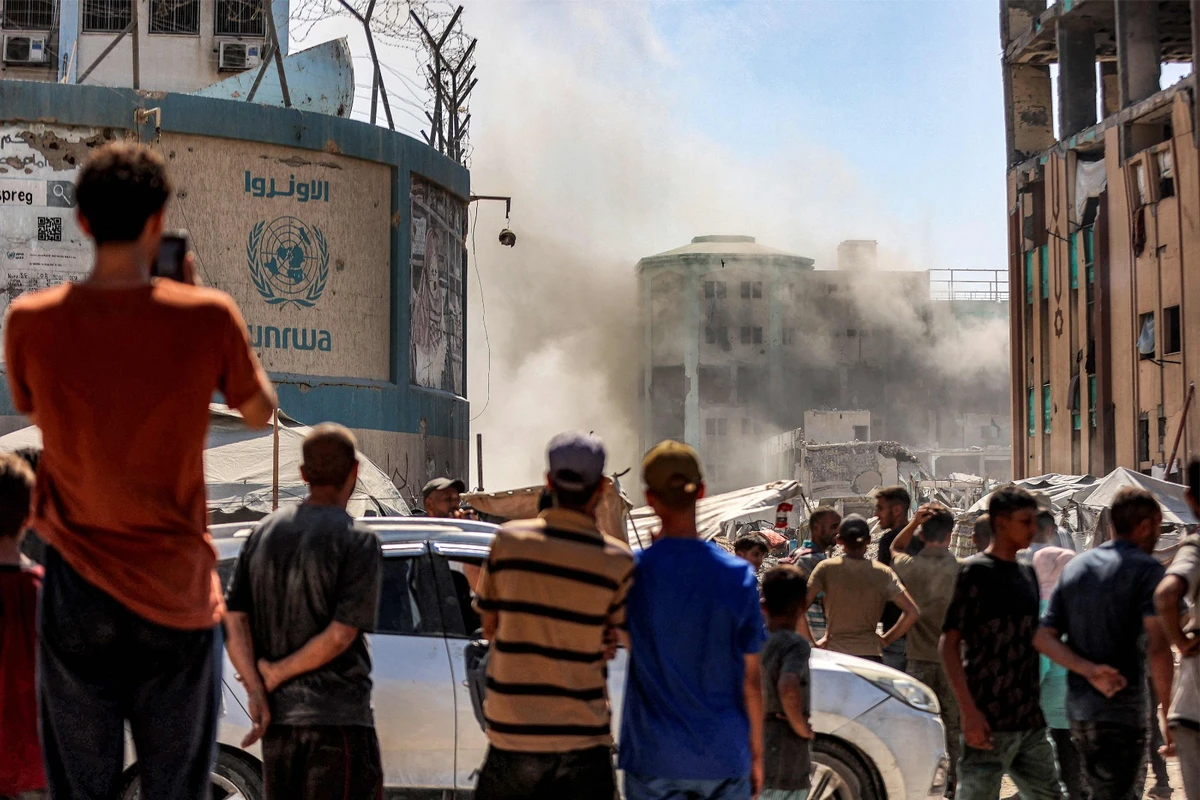 People watch as smoke dissipates following an explosion in one of the buildings of the Islamic University of Gaza in Gaza City on September 14, 2025. (AFP)