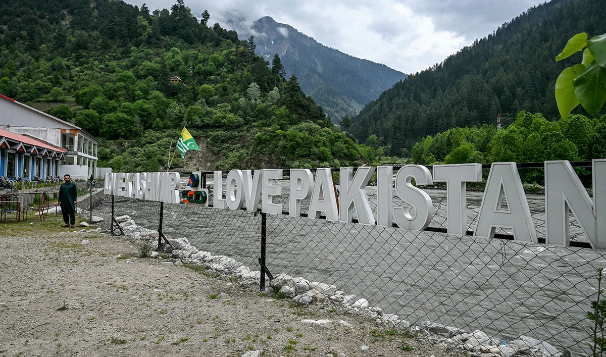 A guest house staff stands in an empty tourist place in Keran village on the Line of Control (LoC) in Neelum Valley, a district of Pakistan-administered Kashmir, on May 3, 2025. (AFP)