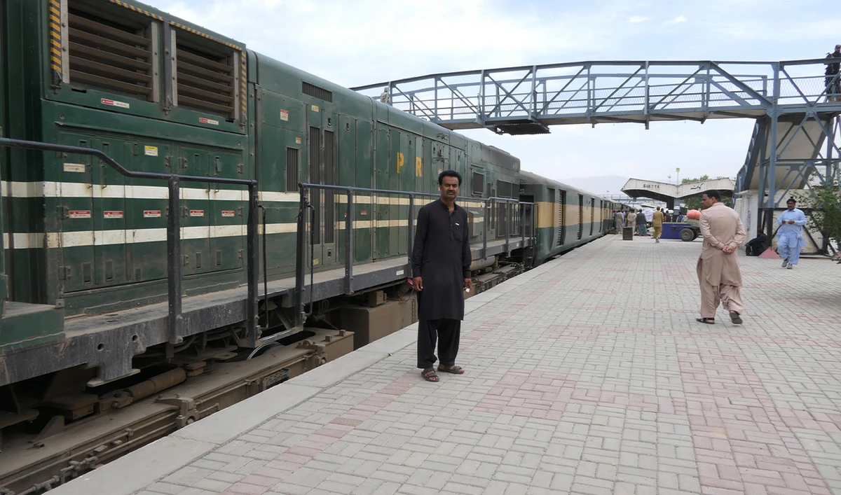 Assad Ali (left), a Pakistan Railways employee and survivor of the Jaffar Express hijacking, watches a train pass by at Quetta Railway Station in Quetta, Pakistan, on April 8, 2025. (AN/File)