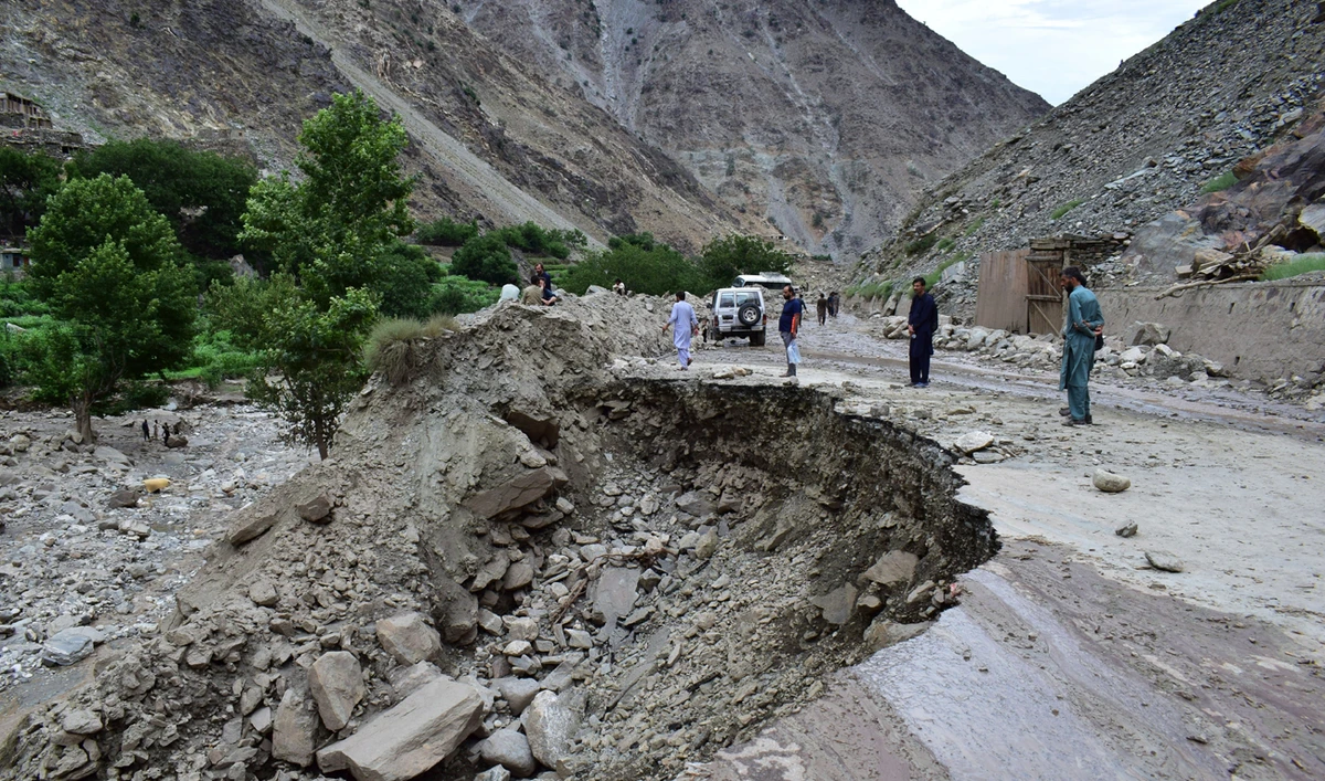 Local residents walk on a damaged road following a cloudburst triggered landslide and flash flood on a highway near the Chilas district, northern Pakistan, on July 23, 2025. (AP/File)