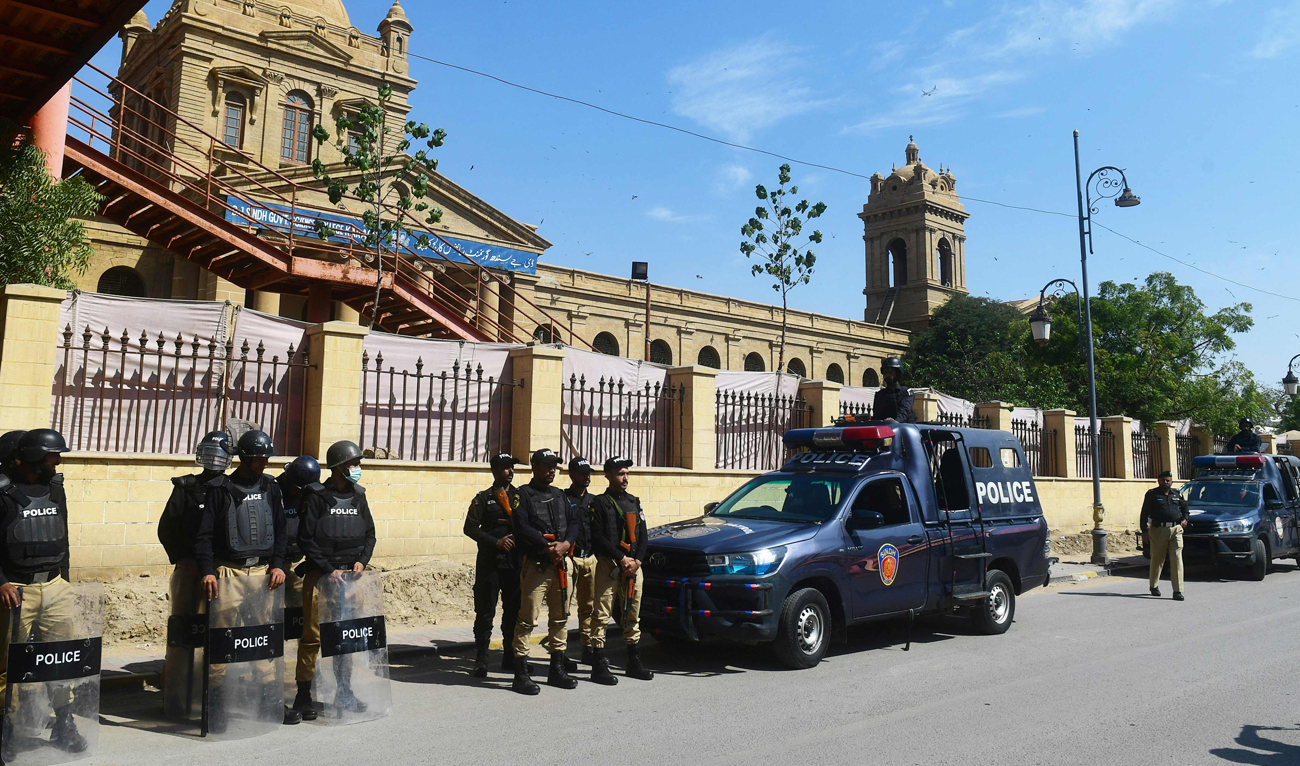 In this file photo, taken on February 8, 2024, policemen stand guard on a street in Karachi. (AFP/File)