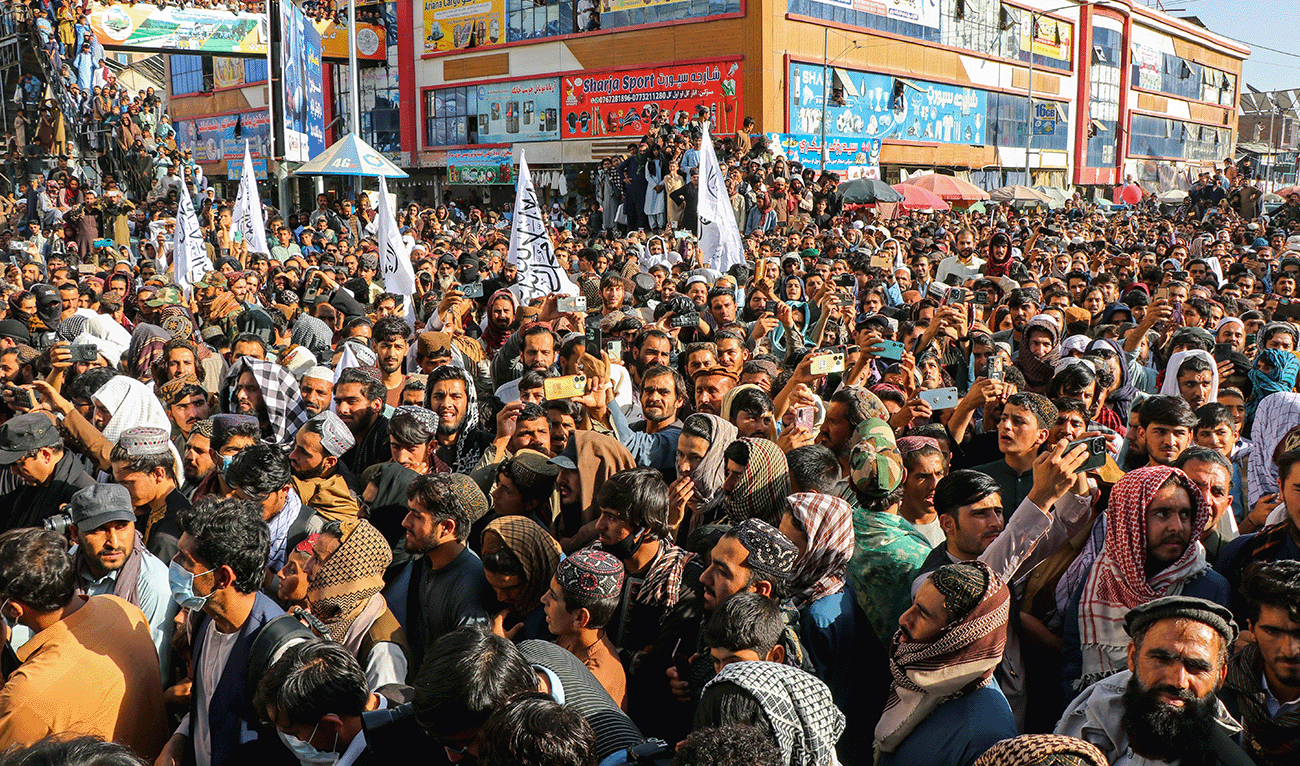 Afghan men carry the Taliban flag as they gather in support of Afghanistan's Taliban government during a rally in Khost on October 13, 2025, amid heavy cross-border clashes between Afghanistan and Pakistan. (AFP)