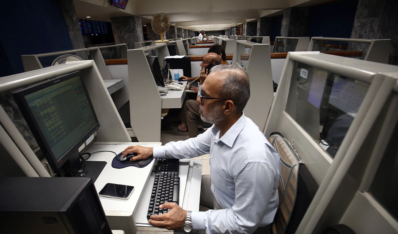 A stockbroker monitors share prices on computers during a trading session at the Pakistan Stock Exchange (PSX) in Karachi on October 2, 2025. (EPA/File)