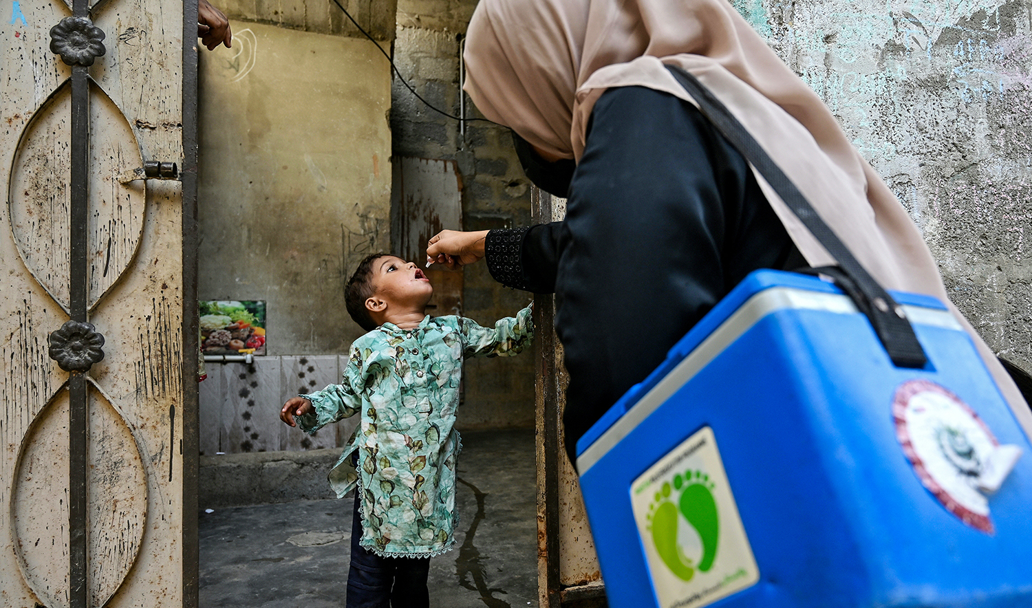 A health worker administers polio drops to a child for vaccination on the first day of a nationwide week-long poliovirus eradication campaign in Karachi on October 13, 2025. (AFP/File)
