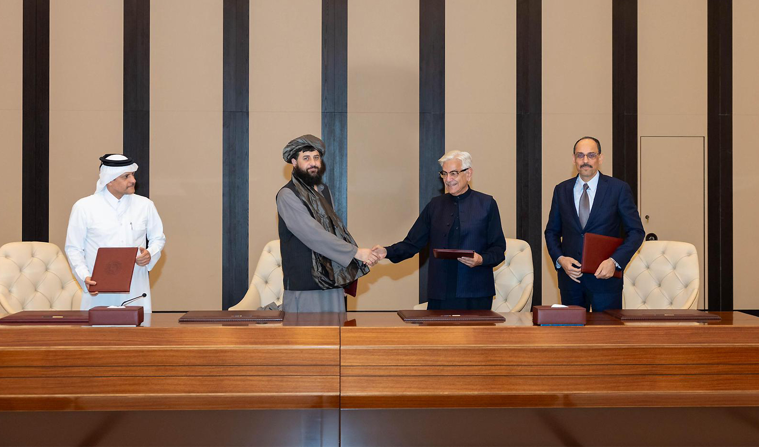Pakistani Defence Minister Khawaja Asif, center right, and Afghan Defence Minister Mullah Muhammad Yaqoob shake hands after signing a ceasefire agreement in Doha, Qatar, on October 19, 2025.(Qatar Ministry of Foreign Affairs via AP)
