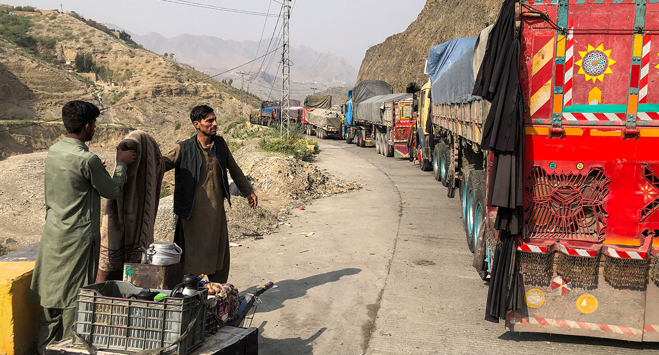 A tea vendor stands near the stalled vehicles near the closed Pakistan-Afghanistan border town of Torkham on October 19, 2025, after cross-border clashes between the two countries. (AFP)