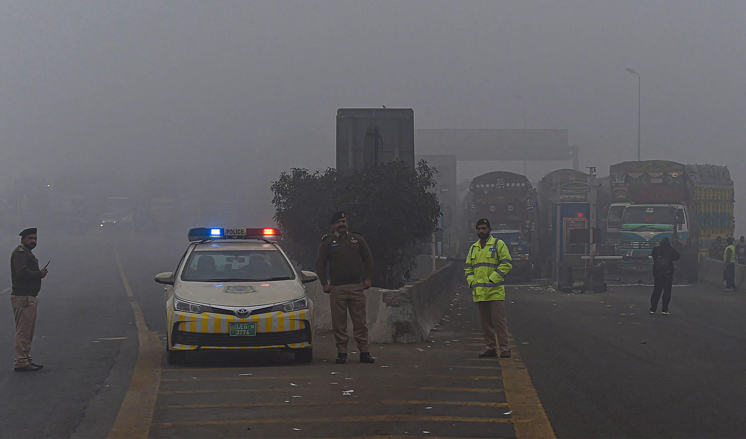 Traffic policemen stand along a motorway as it was closed by the authorities due to smoggy conditions early in the morning in Lahore on December 16, 2021. (AFP/File)