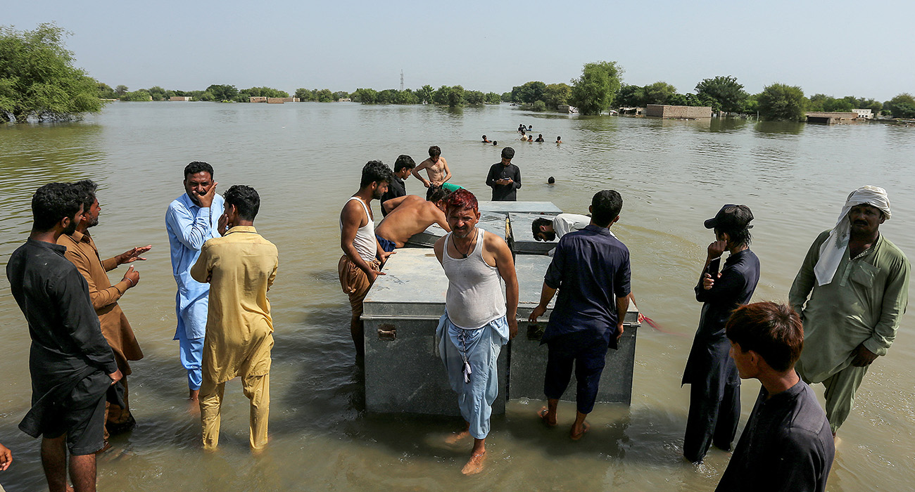 Flood-affected people carrying belongings wade through floodwater as they reach a safer place with their belongings near a closed motorway damaged by floodwater in Jalalpur Pirwala, in the Multan district of Punjab province on September 17, 2025, after the Chenab River overflowed following heavy monsoon rains. (AFP/ file)