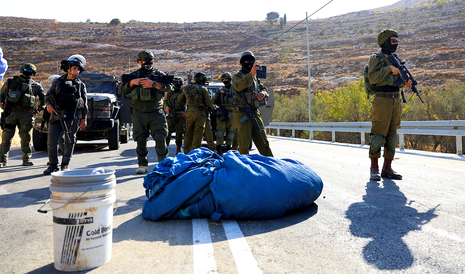 Members of the Israeli forces stand guard as they block the access of Palestinians and foreign activists to olive trees during the olive harvest, near Hebron, in the Israeli-occupied West Bank, on October 23, 2025. (REUTERS)