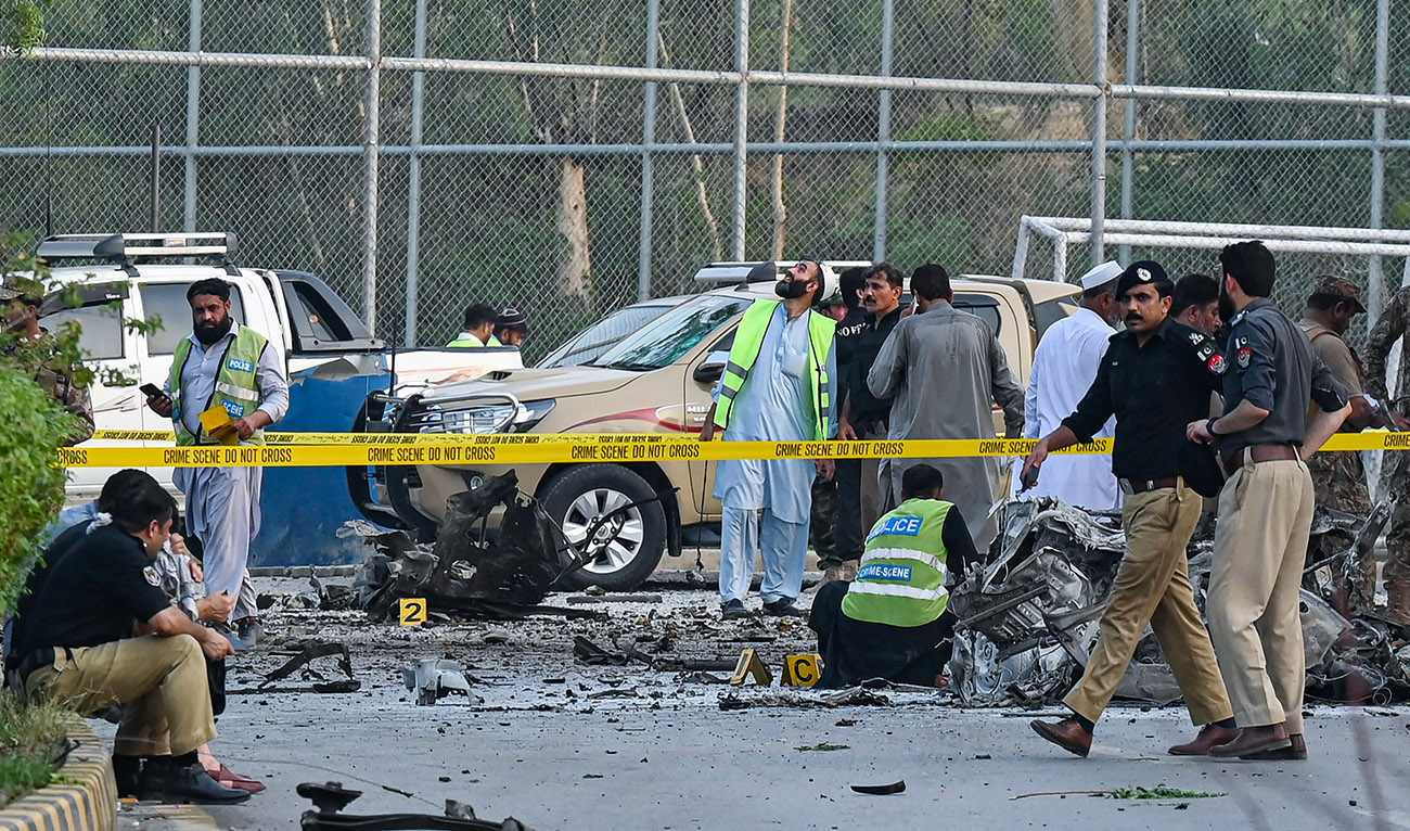Security personnel gather at the site of the bomb blast in Hayatabad area of Peshawar, Pakistan, on July 18, 2023. (AFP/File)