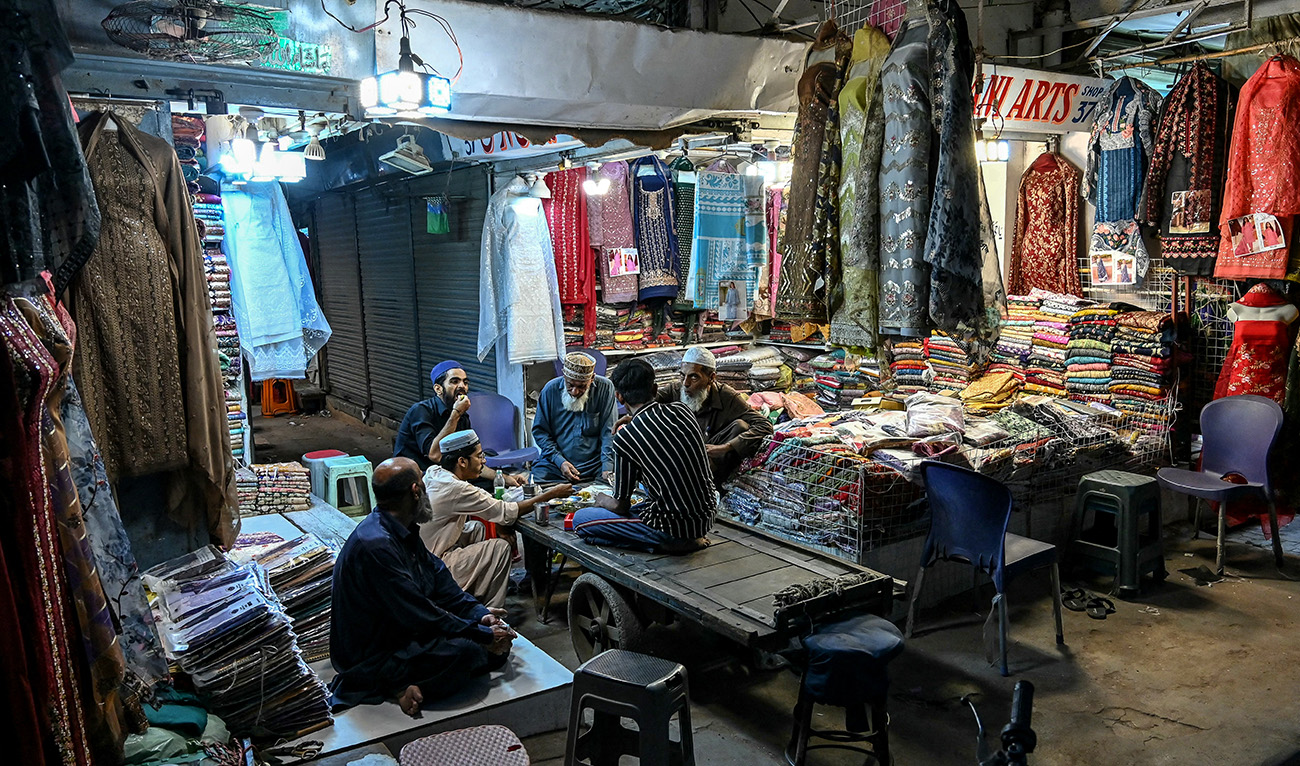 Shopkeepers break their fast at a market during the Islamic holy fasting month of Ramadan in Karachi on March 9, 2025. (AFP/ file)