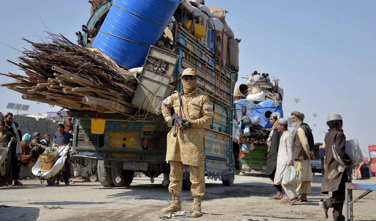 A Taliban security personnel stands guard as deported Afghan refugees from Pakistan arrive at the zero-point border crossing between Afghanistan and Pakistan, in the Spin Boldak district of Kandahar province on October 27, 2025. (AFP/File)