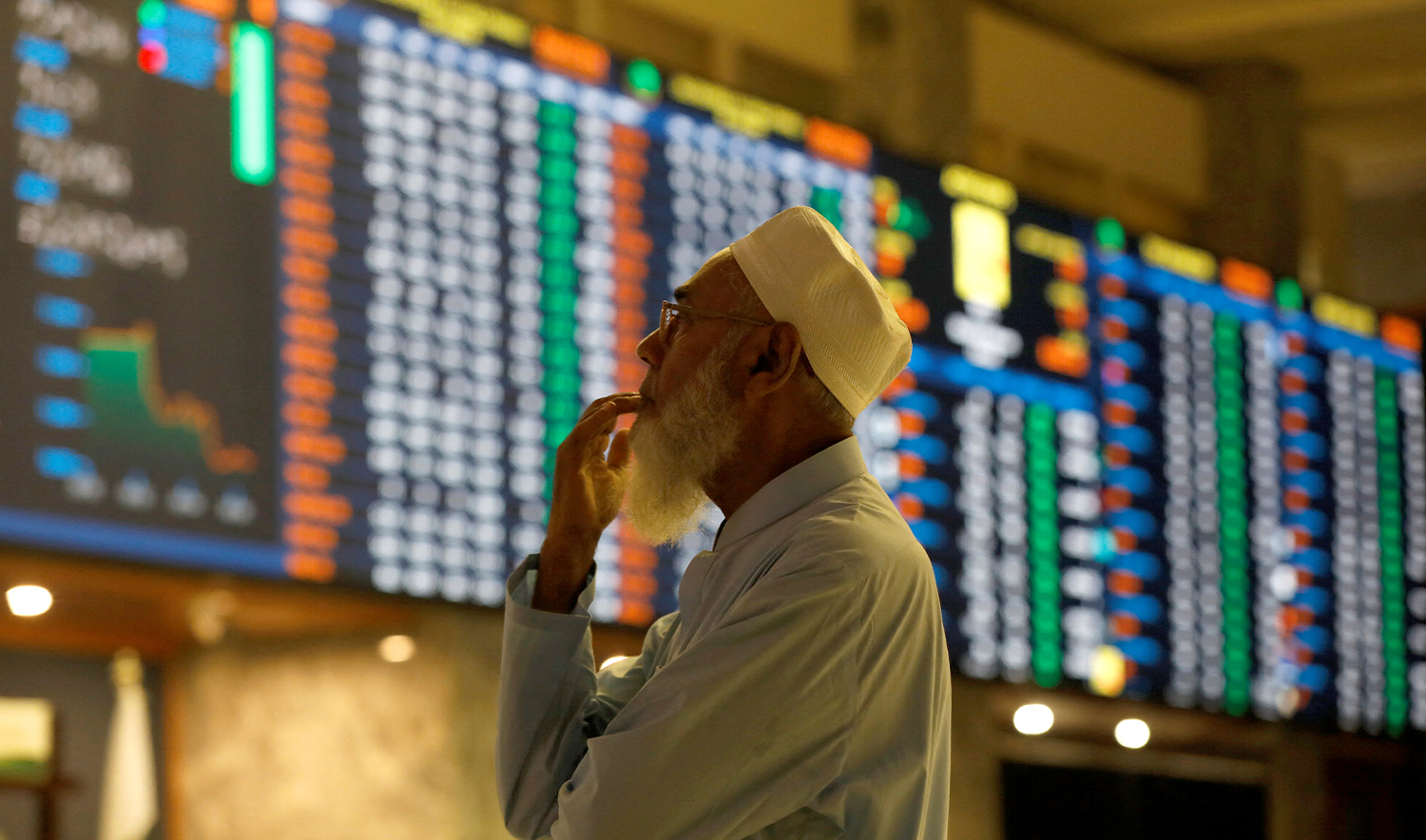 A stock broker reacts while monitoring the market on the electronic board displaying share prices during trading session at the Pakistan Stock Exchange, in Karachi, Pakistan July 3, 2023. (REUTERS/File)