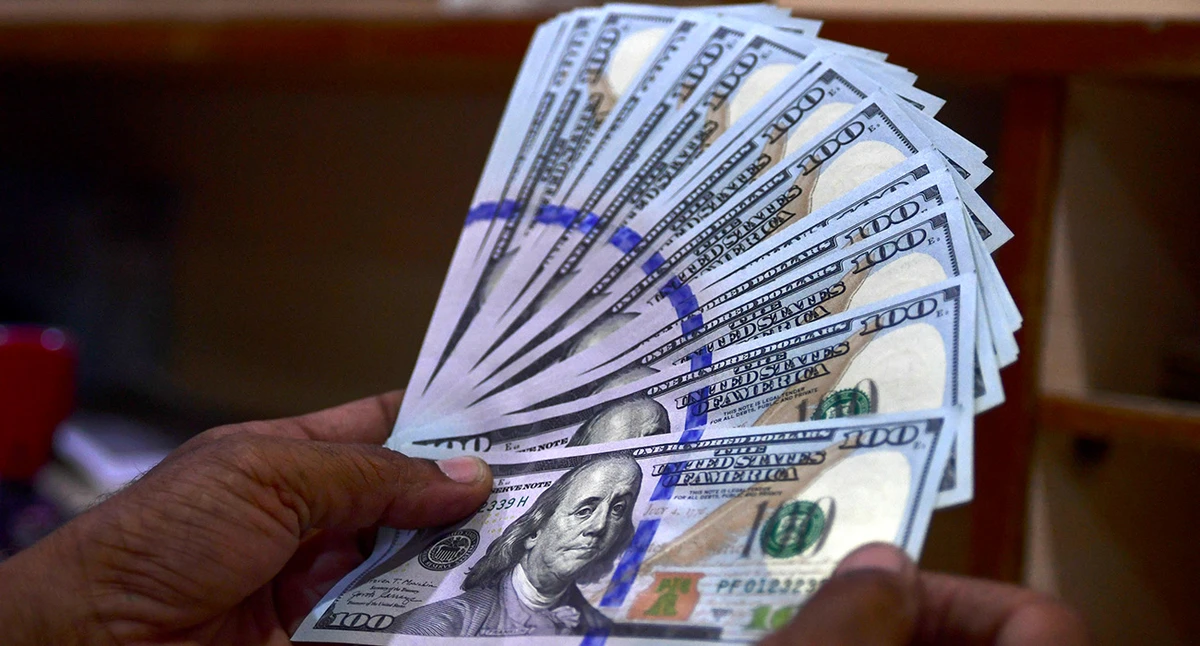 A foreign currency dealer counts US dollar notes at a currency market in Karachi on July 19, 2022. (AFP/ file)
