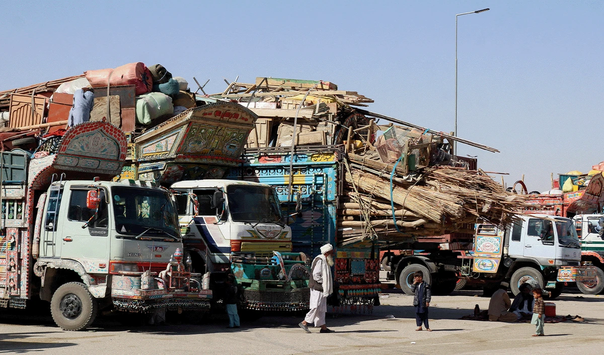A man walks near children next to parked vehicles loaded with the belongings of Afghan citizens attempting to return to their country, after Pakistan closed border crossings with Afghanistan following exchanges of fire between the nations' forces, at the border crossing in Chaman, Balochistan Province, Pakistan October 16, 2025. (Reuters/File)