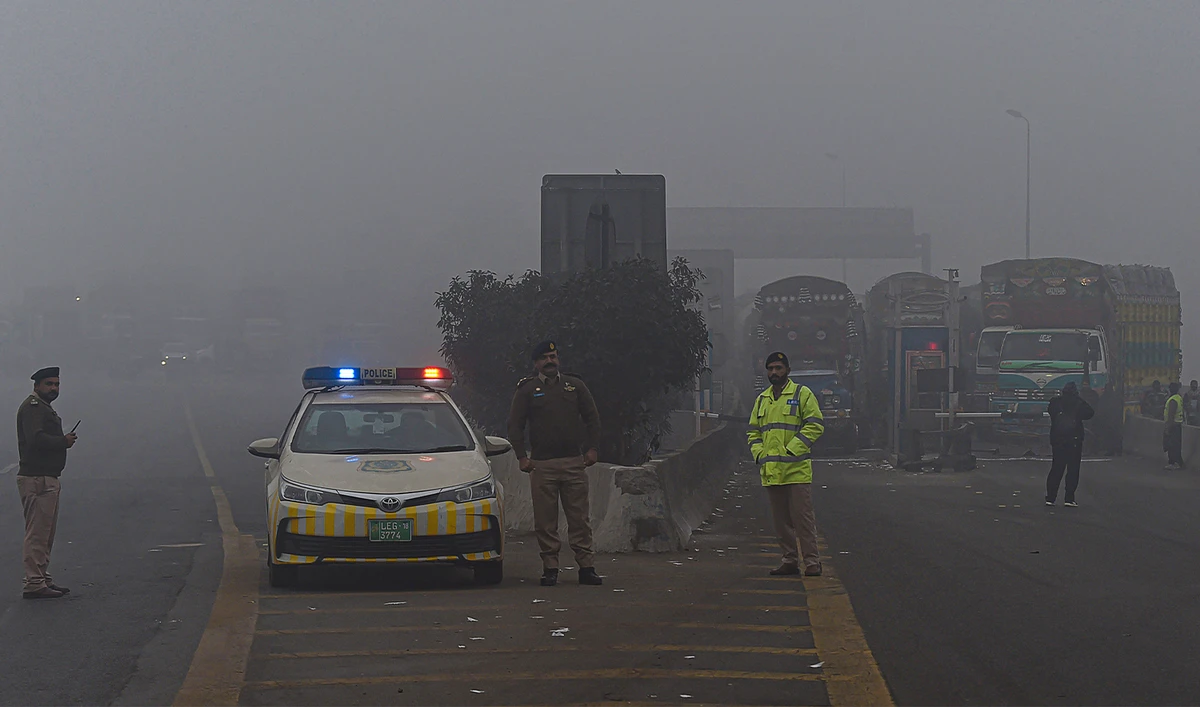 Traffic policemen stand along a motorway as it was closed by the authorities due to smoggy conditions early in the morning in Lahore on December 16, 2021. (AFP/File)