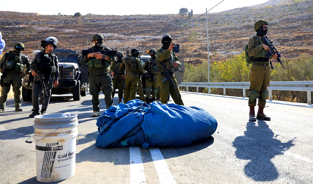 Members of the Israeli forces stand guard as they block the access of Palestinians and foreign activists to olive trees during the olive harvest, near Hebron, in the Israeli-occupied West Bank, on October 23, 2025. (REUTERS)