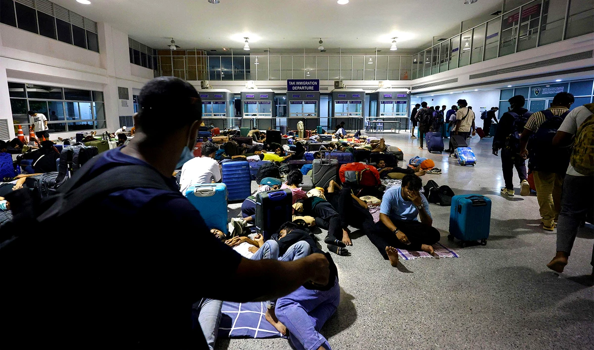 People, who had crossed over from Myanmar, gather as they wait to be screened and interrogated by Thai officials at the Second Thai-Myanmar Friendship Bridge Immigration Checkpoint in Mae Sot District, Tak Province on October 23, 2025. (AFP)