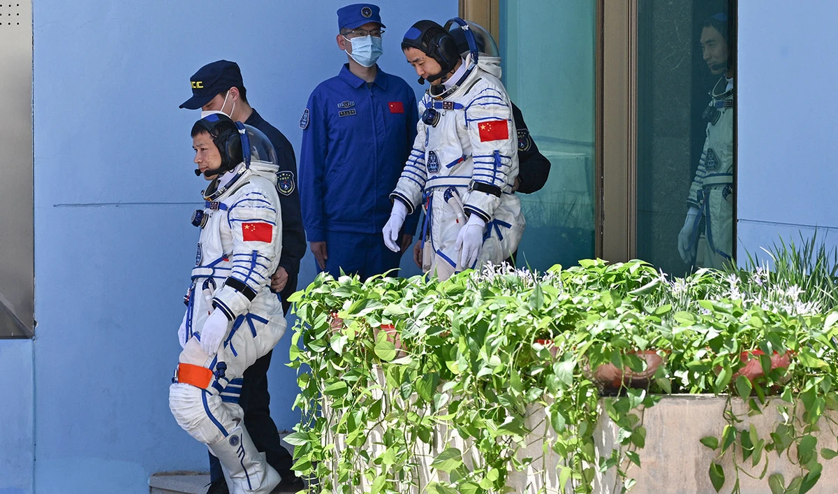 Astronauts for China's Shenzhou-20 space mission Wang Jie, Chen Dong, and Chen Zhongrui arrive to a departure ceremony before boarding a bus to take them to the Shenzhou-20 spaceship at the Jiuquan Satellite Launch Centre in the Gobi desert in northwest China on April 24, 2025. (AFP)