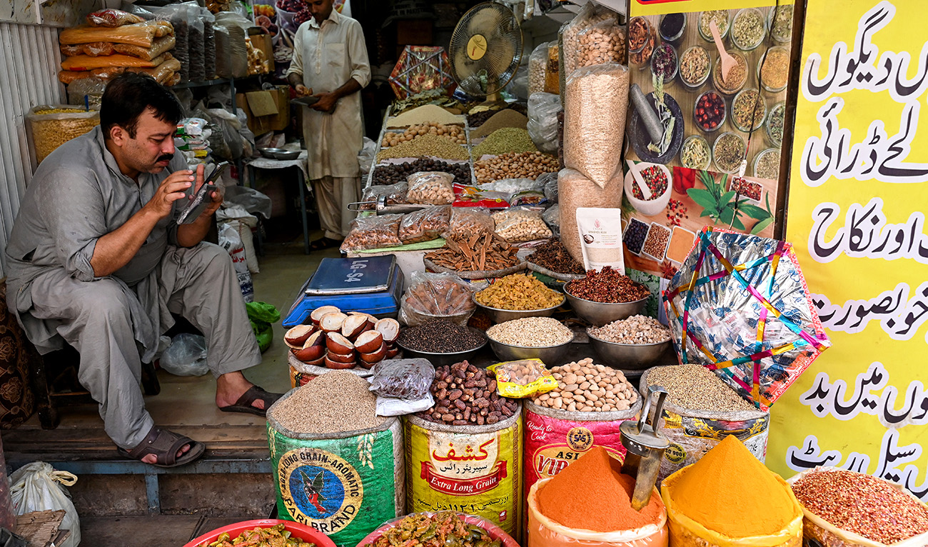 A shopkeeper selling spices waits for customers at a market in Lahore on June 9, 2025, on the eve of Pakistan's federal budget unveiling. (AFP/ file)
