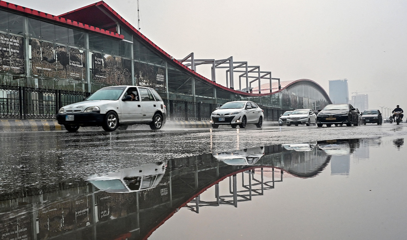 Commuters make their way through a road as it rains in Islamabad on November 4, 2025. AFP)