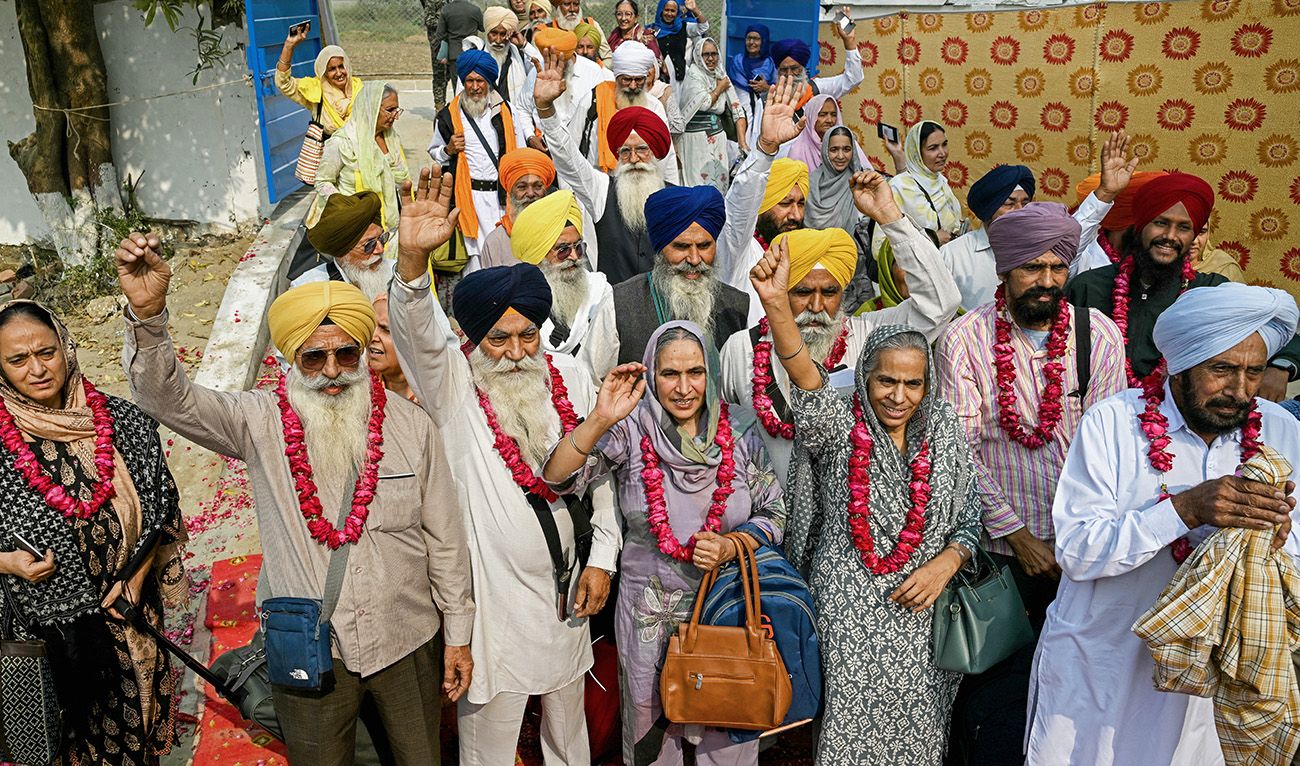 Indian Sikh pilgrims gesture upon their arrival in Pakistan after crossing the India-Pakistan Wagah border in Wagah on November 4, 2025, on the eve of celebrations marking the birth anniversary of Guru Nanak, founder of Sikhism. (AFP)