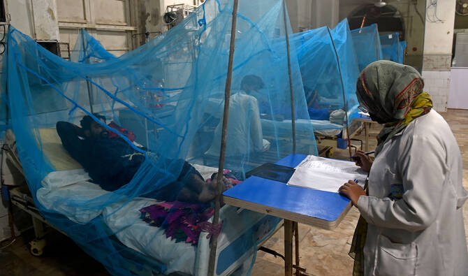 Patients suffering from dengue fever rest under mosquito nets at a hospital in Karachi on October 4, 2022. (AFP/File)