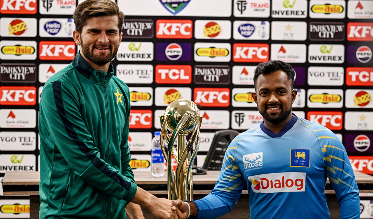 Pakistan's captain Shaheen Shah Afridi (L) and his Sri Lankan counterpart Charith Asalanka shake hands as they pose with the series trophy on the eve of their first one-day international (ODI) cricket match at the Rawalpindi Cricket Stadium in Rawalpindi on November 10, 2025. (AFP)