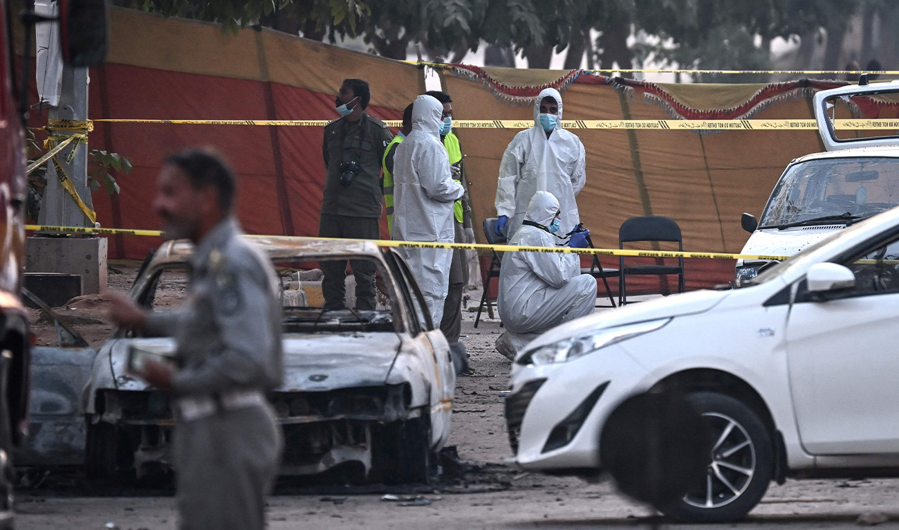 Forensic experts examine a car after a suicide blast outside the district court in Islamabad on November 11, 2025. The Pakistani Taliban claimed a suicide bombing that killed at least 12 people in Islamabad on November 11, a rare attack by the militant group on the country's capital. (AFP)
