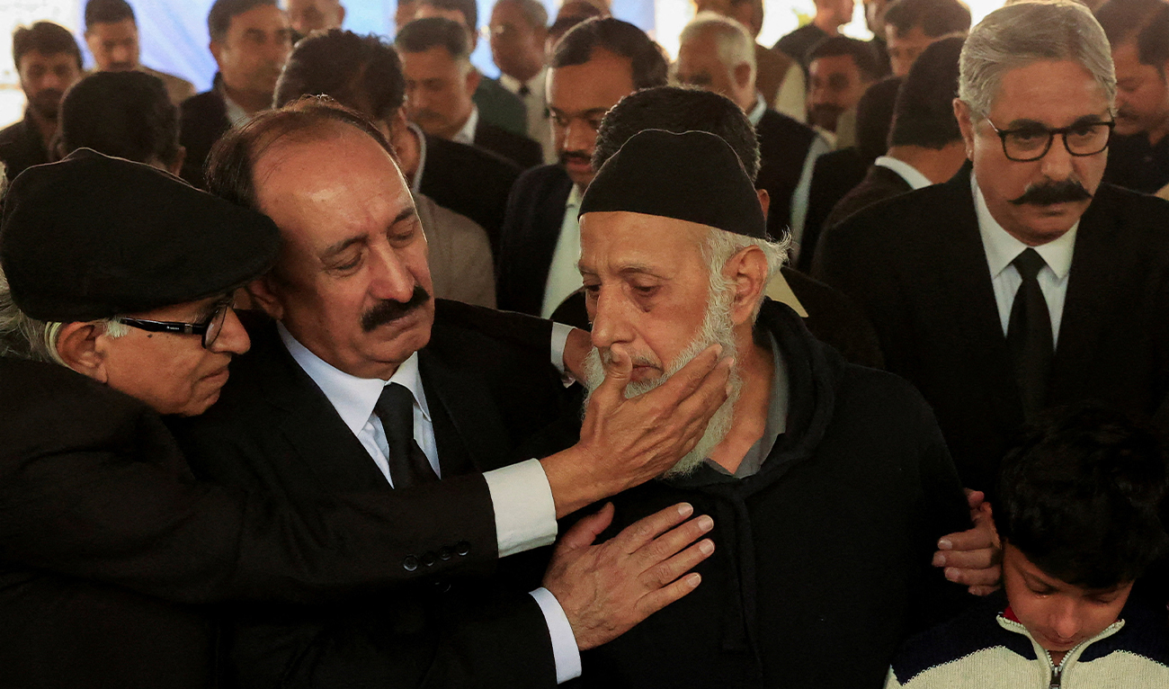 Mourners comfort Aslam Ghuman (center), father of the deceased lawyer, during his son’s funeral in Islamabad on November 12, 2025, a day after the suicide bombing. (AFP)