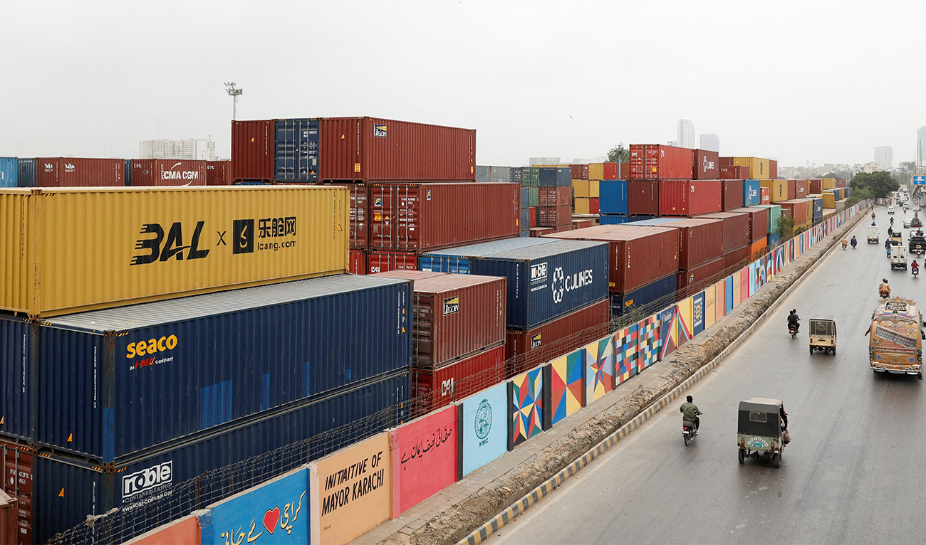 Vehicles move past a warehouse yard with shipping containers near the port area in Karachi, Pakistan, on July 31, 2025. (REUTERS/File)