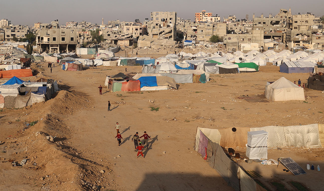 Children play near shelters and tents in the Bureij refugee camp, in the central Gaza Strip, on November 18, 2025. (AFP)
