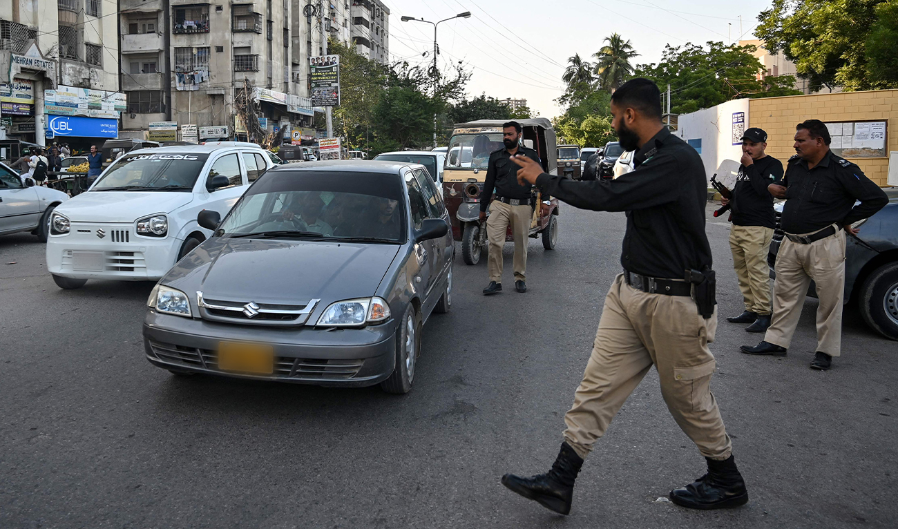 A policeman stops vehicles for searches along a road in Karachi, Pakistan, on November 12, 2025. (AFP/File)