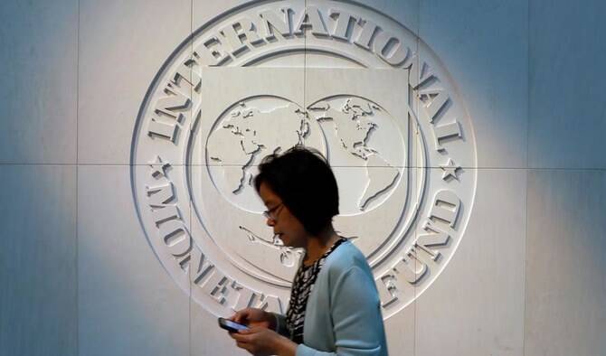 A woman walks past the International Monetary Fund (IMF) logo at its headquarters in Washington DC, United States, on May 10, 2018. (REUTERS/File)
