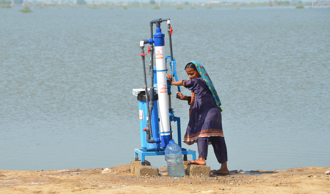 A flood-affected girl collect water from a filter pump in Dera Allah Yar town of Jaffarabad district in Balochistan province on September 17, 2022. (AFP/File)