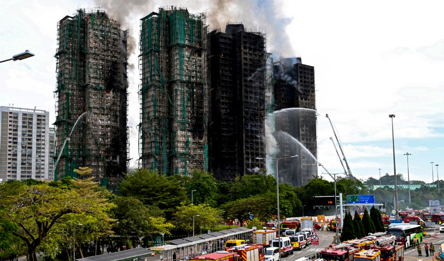 Firefighters spray water on flames as a major fire burns through several apartment blocks at the Wang Fuk Court residential estate in Hong Kong's Tai Po district on November 27, 2025. (AFP)