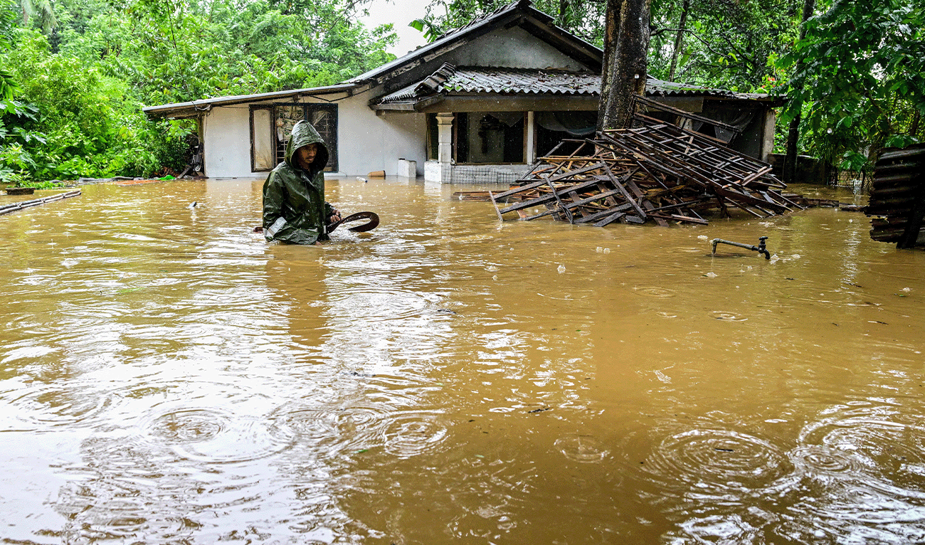 A man wades through floodwaters outside his house after heavy rainfall in Kaduwela on the outskirts of Colombo on November 28, 2025. (AFP)