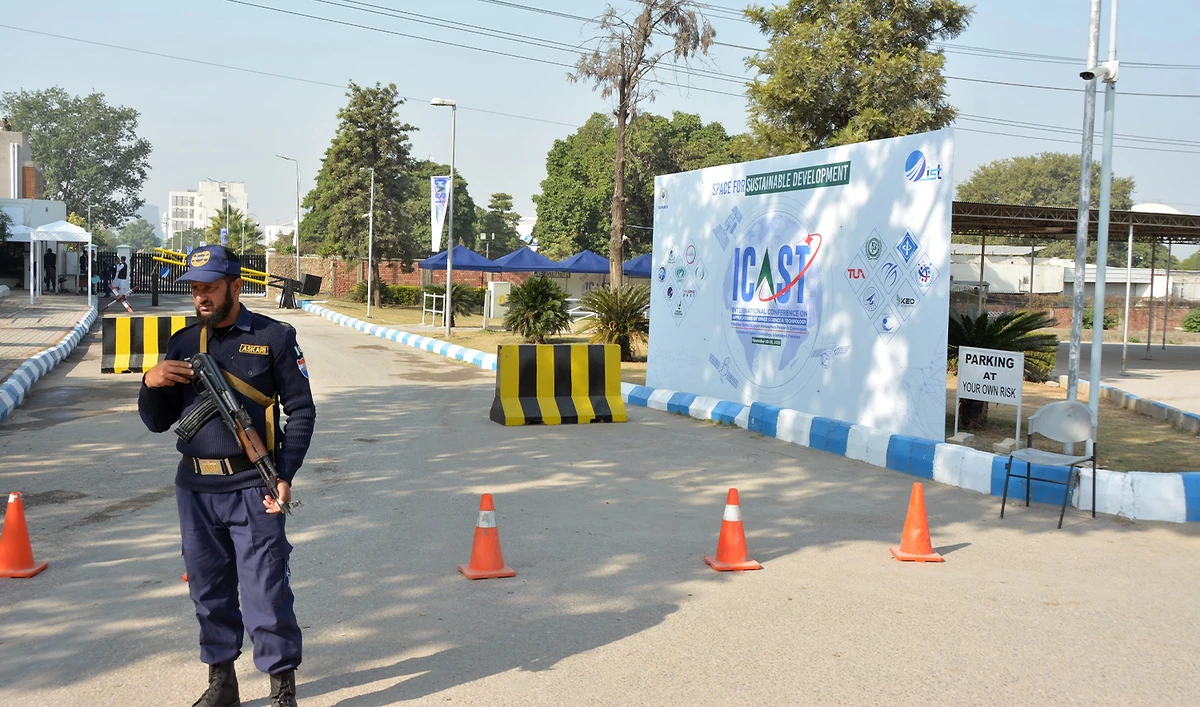 A security guard is standing near ICAST 2025 conference banner at Institutre of Space Technology in Islamabad, Pakistan, on November 17, 2025. (ICAST)