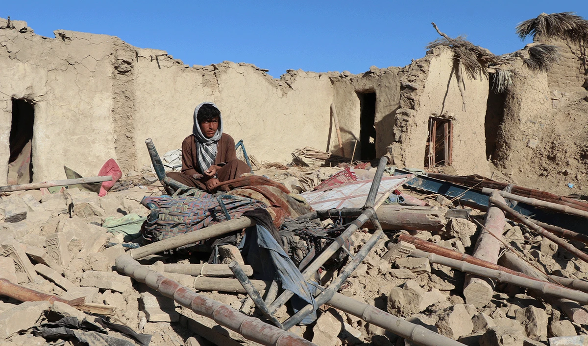 A resident sits at a damaged house after an air strike by Pakistan, in Jige Mughalgai in Khost province on November 25, 2025. (AFP)