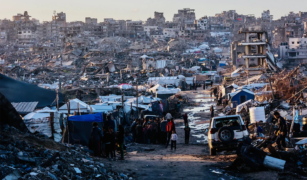 Displaced palestinians stand on a road after heavy rain in Jabalia city, northern Gaza Strip, on November 25, 2025. (AFP)
