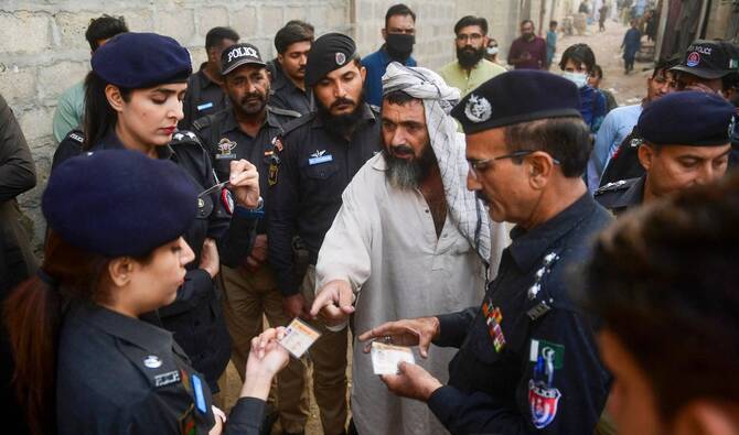 Police personnel check documents of Afghan refugees during a search operation to identify alleged illegal immigrants, on the outskirts of Karachi on November 17, 2023. (AFP/File)