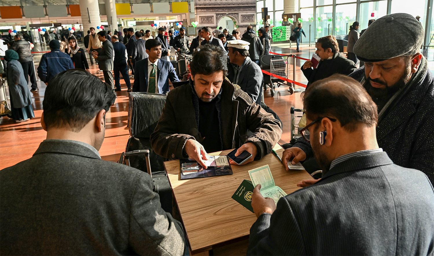 Immigration officers check documents of passengers before boarding their Pakistan International Airlines (PIA) flight to Paris at the Islamabad International Airport on January 10, 2025. (AFP/Filr)